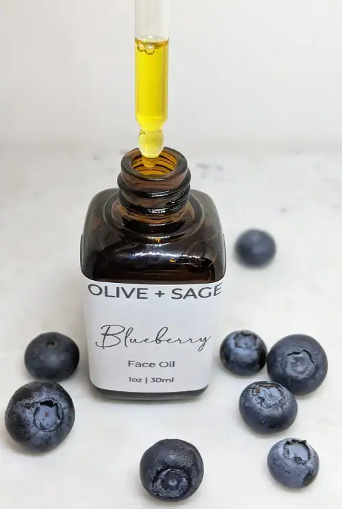 Organic Blueberry Face Oil with key ingredients like blueberries, goji berries, and pomegranate displayed around the bottle – Hydrating and brightening serum for smooth, glowing skin