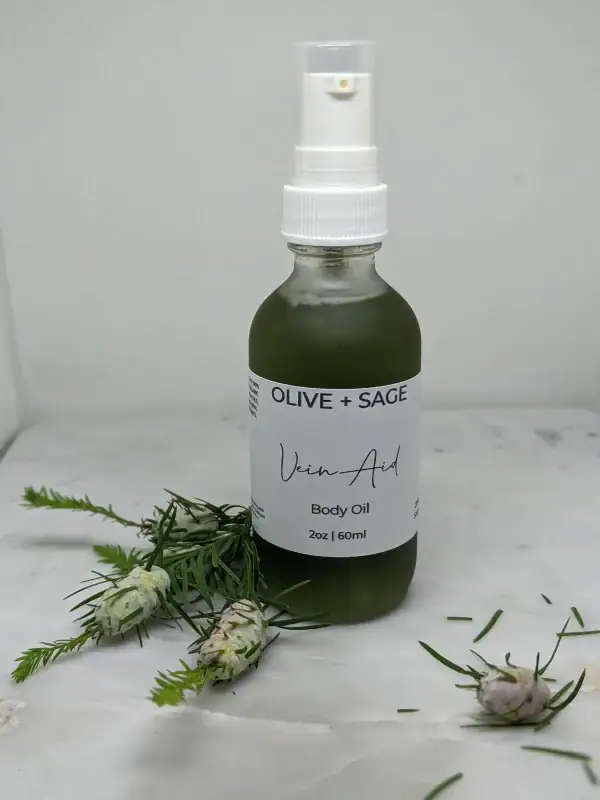 Pump bottle of Enhanced Vein Oil with pine decorations, designed to support circulation and improve skin tone.