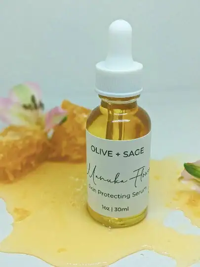 Manuka Flower Skin Protecting Serum in dropper bottle surrounded by honey