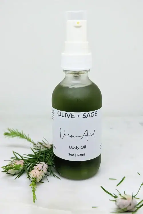 Natural Vein Oil in a pump bottle, labeled, with pine decorations for enhanced circulation and smoother skin.
