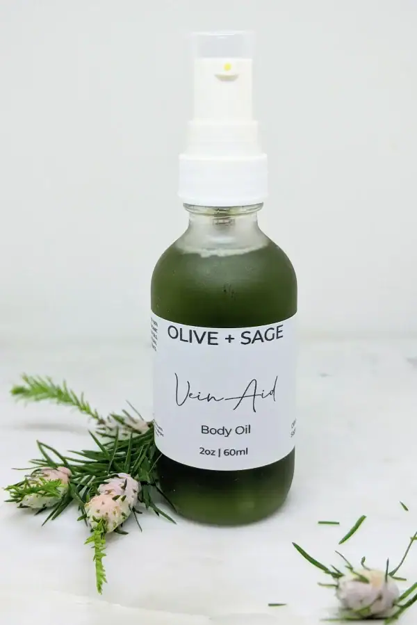 Natural Vein Oil in a pump bottle, labeled, with pine decorations for enhanced circulation and smoother skin.