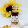 Nature’s Retinol Face Oil bottle with dropper resting beside it and sunflower in background. Plant-based retinol alternative by Olive + Sage.