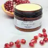 Organic Belly Balm in jar with lid off surrounded by pomegranates, perfect for preventing stretch marks during pregnancy.