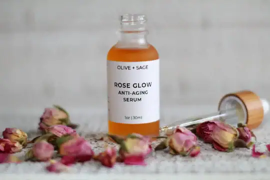 Rose Glow Anti-Aging Serum dropper bottle with the dropper out and dried mini roses
