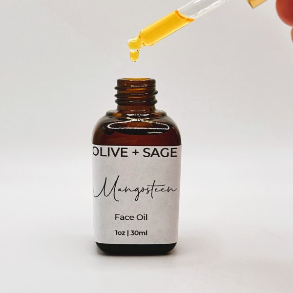Mangosteen Face Oil dropper above the bottle, with a drop of oil falling into the bottle