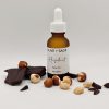 Front-facing image of organic hazelnut face oil bottle with cocoa, vanilla, and hazelnuts