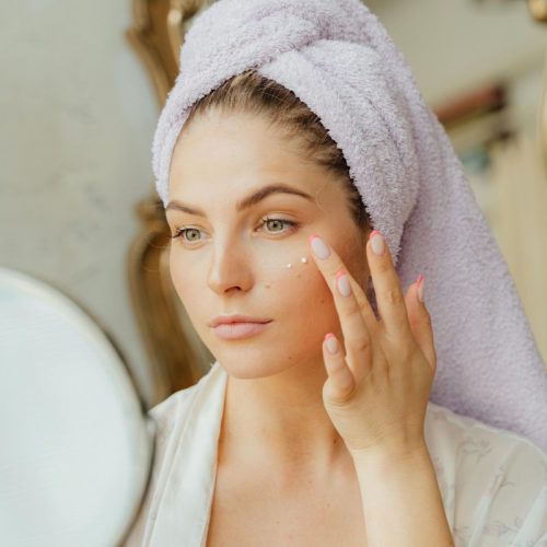 Woman applying organic facial skincare cream for hydration and balance