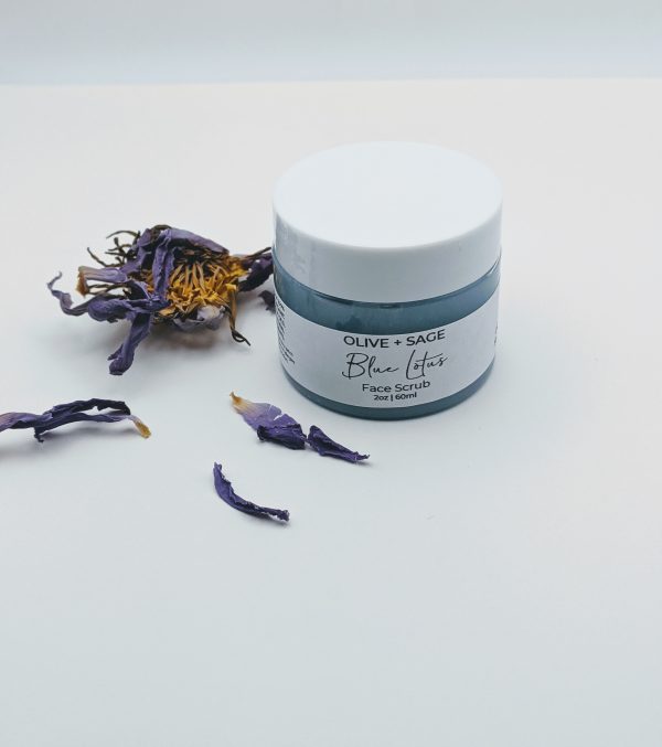 Closed jar of Blue Lotus Face Scrub with a fresh blue lotus flower beside it