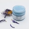 Open jar of Blue Lotus Face Scrub with blue lotus flower showing the texture