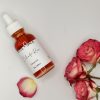 Delicate Rose Face Oil flatlay styled with pink roses